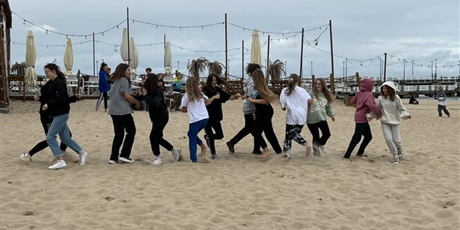 Powiększ grafikę: Grupa dziewcząt tańczących na plaży.