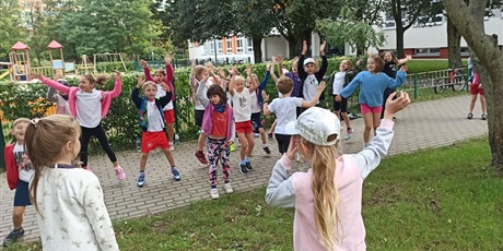 Powiększ grafikę: Grupa dzieci tańcząca na szkolnym podwórku 