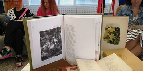 Powiększ grafikę: Na pierwszym planie stojące i leżące otwarte książki z tekstami Adama Mickiewicza.