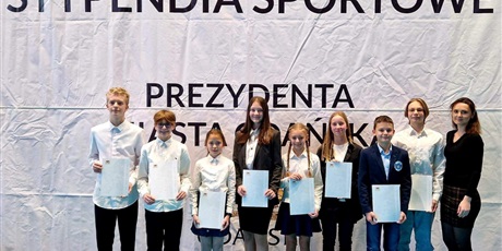 Powiększ grafikę: Uczniowie, którzy otrzymali stypendia pozują do wspólnego zdjęcia na tle napisu "Stypendia sportowe Prezydenta Miasta Gdańska"